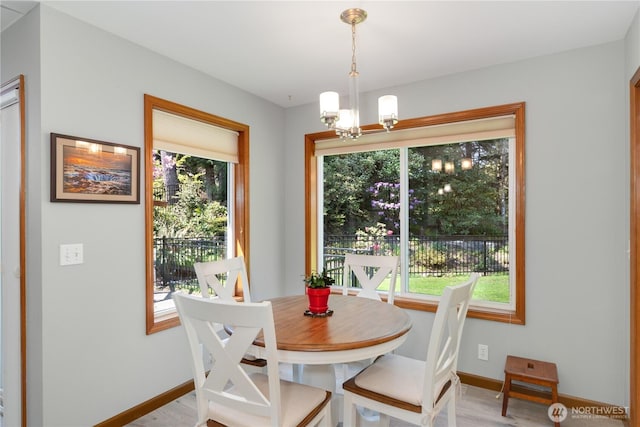 dining area featuring plenty of natural light, a chandelier, and baseboards