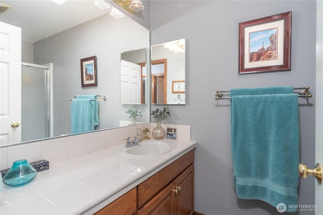 bathroom with a shower stall and vanity
