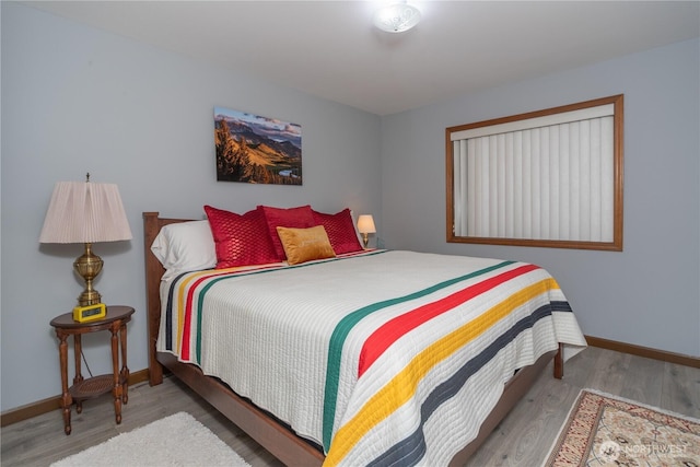 bedroom featuring wood finished floors and baseboards