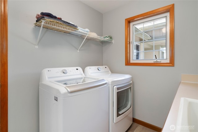 washroom with separate washer and dryer and baseboards