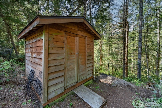 view of shed with a wooded view