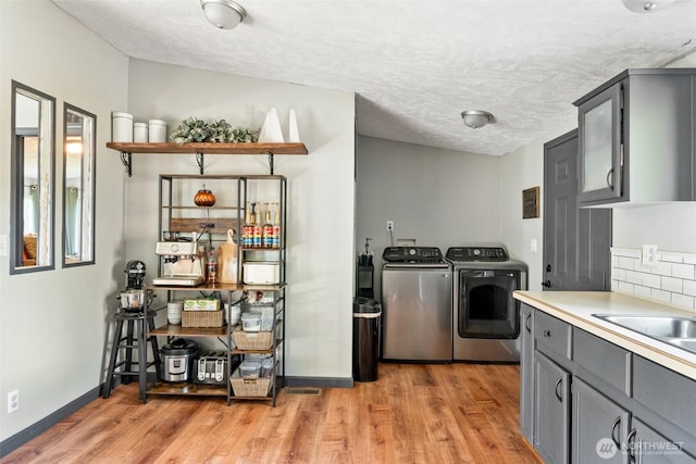 151 Deer Haven Dr, Winlock, WA 98596 - kitchen featuring a textured ceiling, light wood-style floors, gray cabinets, washer and dryer, and baseboards