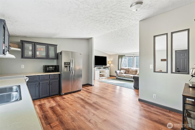 151 Deer Haven Dr, Winlock, WA 98596 - kitchen with light wood finished floors, black microwave, lofted ceiling, and stainless steel refrigerator with ice dispenser