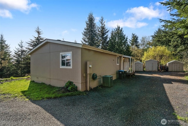 151 Deer Haven Dr, Winlock, WA 98596 - view of home's exterior with central AC unit, an outdoor structure, and a storage unit