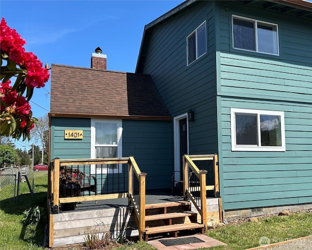 1401 264th Pl, Ocean Park, WA 98640 - back of property featuring a chimney, roof with shingles, a deck, fence, and a yard