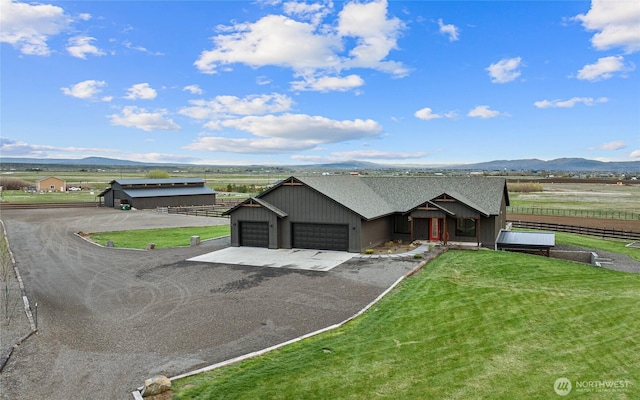 2351 Lower Green Canyon Rd, Ellensburg, WA 98926 - view of front of property with fence, a front lawn, an attached garage, a mountain view, and driveway