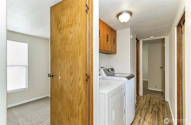 washroom featuring washing machine and dryer, baseboards, a textured ceiling, and cabinet space