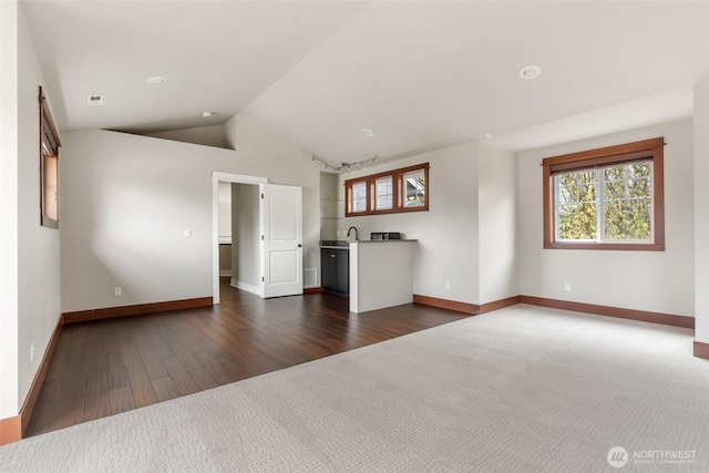 107 Nicola Ct, Chehalis, WA 98532 - unfurnished living room featuring visible vents, baseboards, a sink, dark wood-type flooring, and lofted ceiling