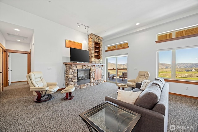 carpeted living area featuring baseboards, recessed lighting, and a fireplace