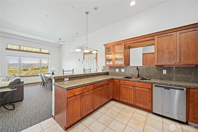 kitchen featuring a sink, light tile patterned flooring, open floor plan, brown cabinets, and dishwasher