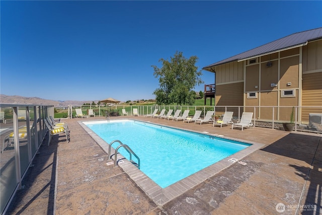 pool featuring fence and a patio area