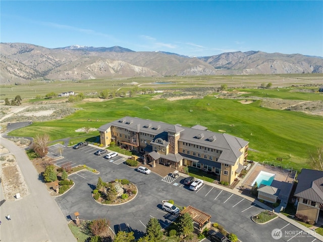 birds eye view of property with view of golf course and a mountain view