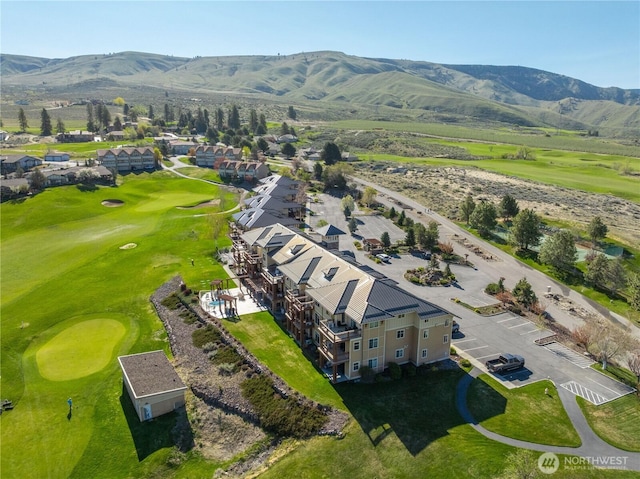 drone / aerial view with a mountain view, golf course view, and a residential view