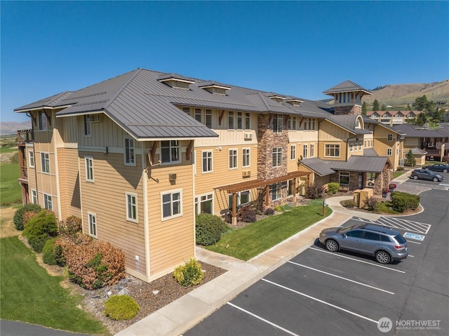 view of building exterior featuring uncovered parking, a mountain view, and a residential view