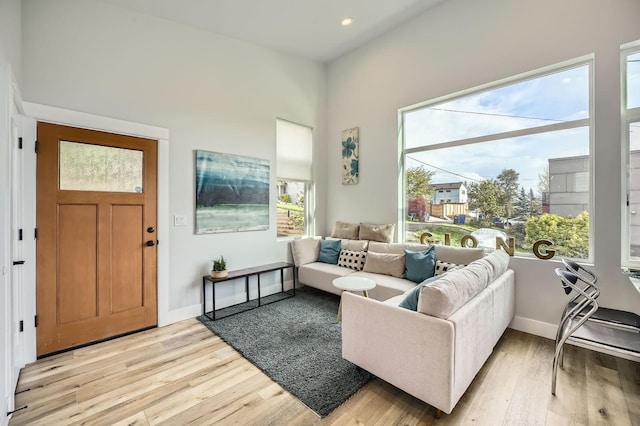 living room with recessed lighting, light wood-type flooring, and baseboards