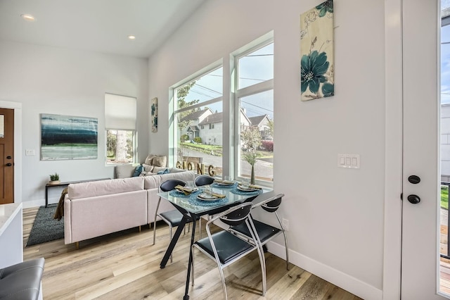 dining room featuring light wood-style flooring, baseboards, and recessed lighting