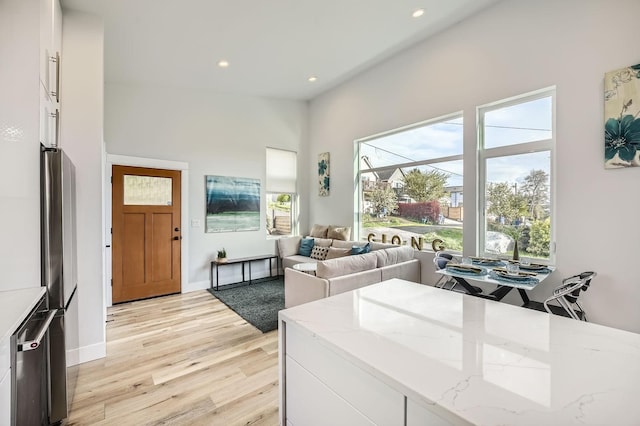 living room featuring light wood-type flooring, baseboards, and recessed lighting