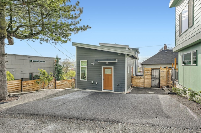 view of front facade with driveway and fence