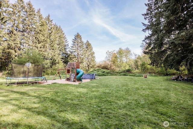view of yard featuring a playground and a trampoline