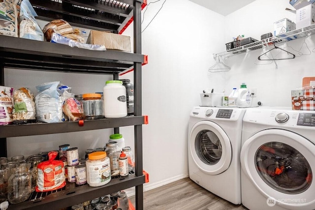clothes washing area with separate washer and dryer, laundry area, baseboards, and light wood finished floors