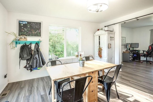 dining area with baseboards, visible vents, and wood finished floors