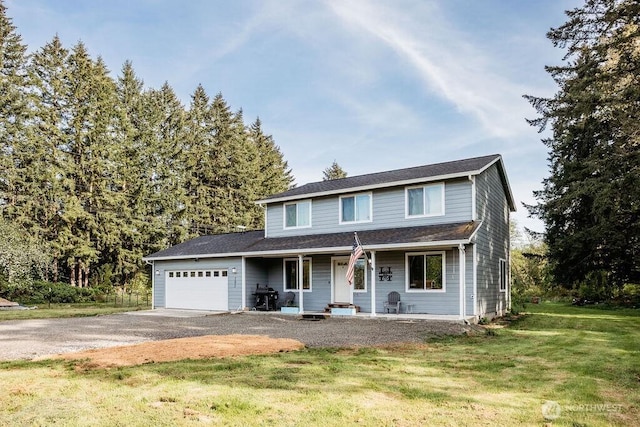 traditional-style home featuring a porch, driveway, a front lawn, and a garage
