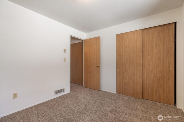 730 SE 8th Ave Unit G202, Oak Harbor, WA 98277 - unfurnished bedroom featuring a closet, baseboards, carpet, and visible vents
