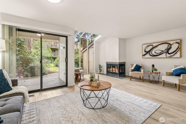 13730 15th Ave NE Unit F-103, Seattle, WA 98125 - living area with wood finished floors, a glass covered fireplace, and baseboards