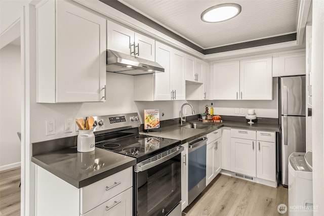 13730 15th Ave NE Unit F-103, Seattle, WA 98125 - kitchen with a sink, appliances with stainless steel finishes, under cabinet range hood, light wood-style flooring, and dark countertops