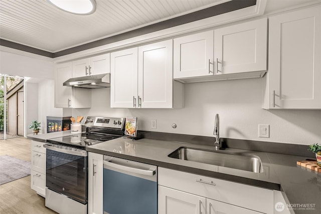 13730 15th Ave NE Unit F-103, Seattle, WA 98125 - kitchen with stainless steel appliances, under cabinet range hood, a sink, white cabinets, and dark countertops