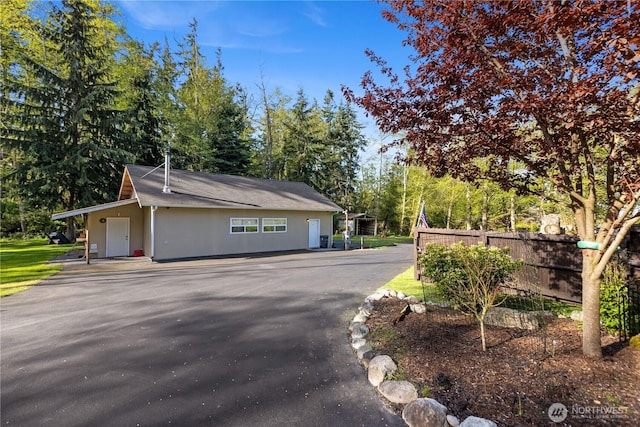 view of side of home with driveway and fence