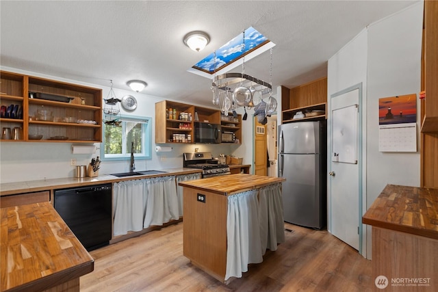 kitchen with an inviting chandelier, open shelves, black appliances, a sink, and butcher block countertops