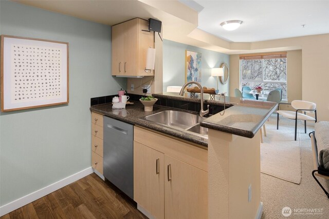 108 5th Ave S Unit 408, Seattle, WA 98104 - kitchen with stainless steel dishwasher, a peninsula, light brown cabinetry, a sink, and baseboards