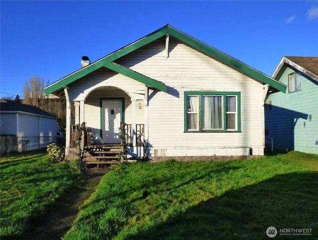 view of front facade with a front yard and covered porch