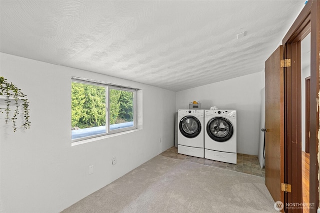 5675 Winona Ln, Langley, WA 98260 - laundry room with light colored carpet, laundry area, washing machine and clothes dryer, and a textured ceiling