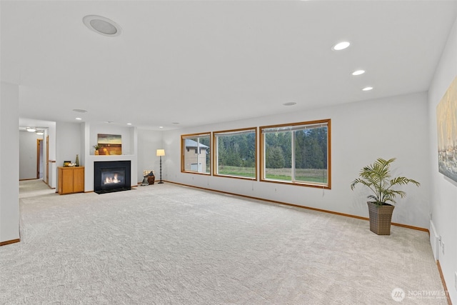 5675 Winona Ln, Langley, WA 98260 - unfurnished living room featuring recessed lighting, a fireplace with flush hearth, carpet, and baseboards