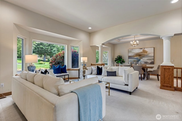 living area with decorative columns, arched walkways, light colored carpet, and recessed lighting