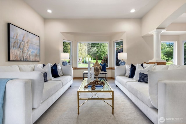 carpeted living area featuring ornate columns, baseboards, and recessed lighting
