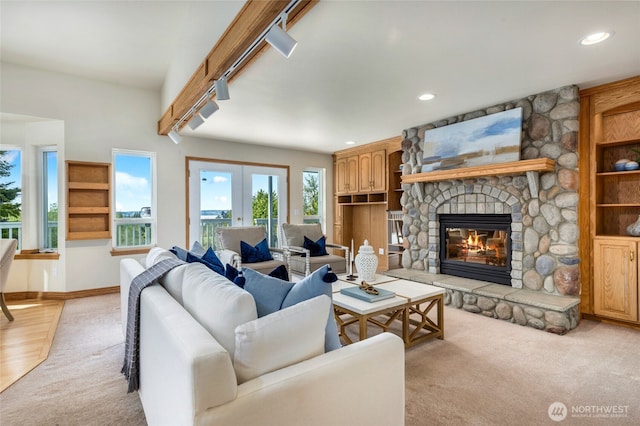 living area featuring baseboards, a fireplace, recessed lighting, french doors, and light colored carpet