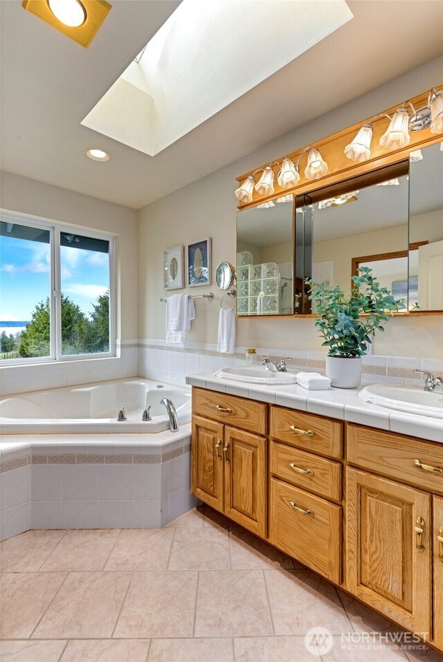 bathroom featuring a skylight, double vanity, and a sink
