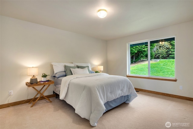 bedroom with light carpet and baseboards