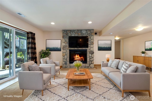 living room with recessed lighting, visible vents, and a stone fireplace