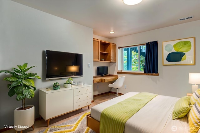 bedroom with built in desk, baseboards, recessed lighting, visible vents, and wood finished floors