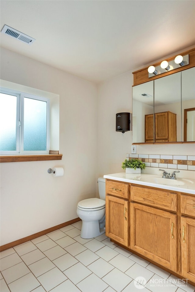 bathroom featuring vanity, visible vents, baseboards, and toilet
