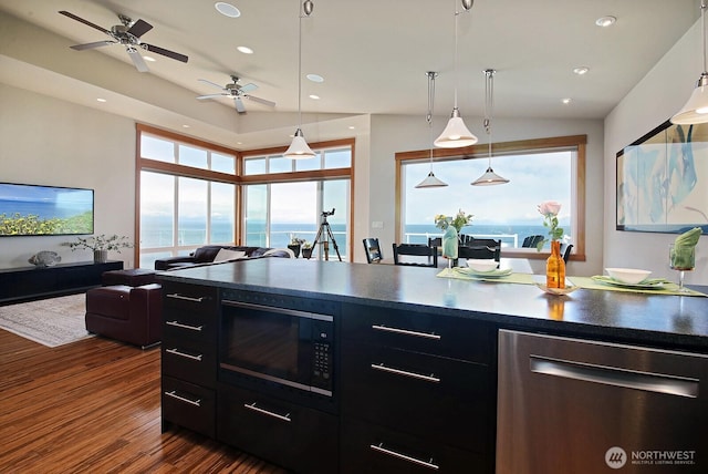 kitchen with dark wood-style flooring, dark countertops, ceiling fan, dark cabinets, and black microwave