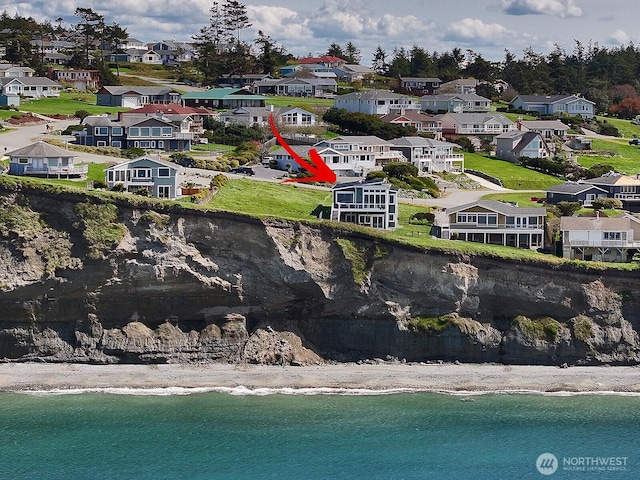 bird's eye view with a beach view, a water view, and a residential view
