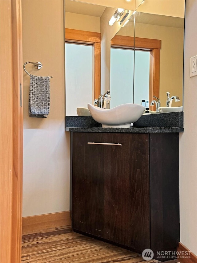 bathroom featuring baseboards, wood finished floors, and vanity