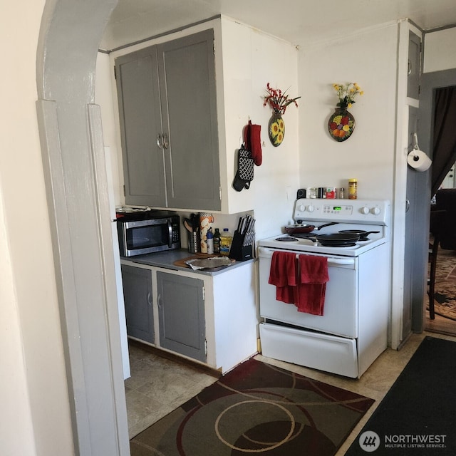 kitchen with stainless steel microwave, gray cabinetry, and electric range