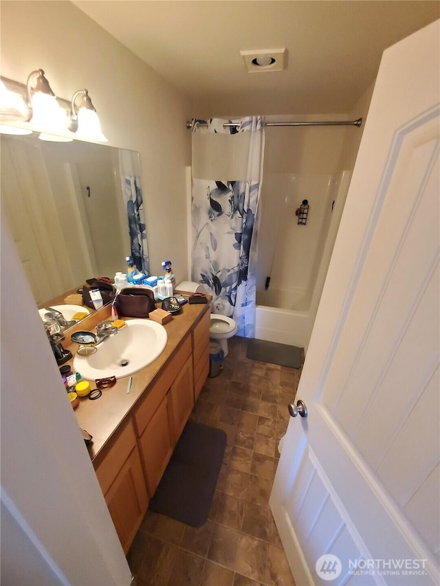 bathroom with shower / bath combo, vanity, and toilet
