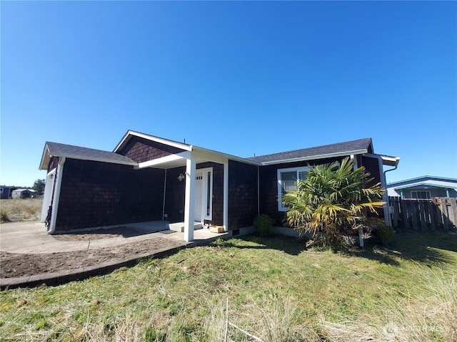 ranch-style house with fence and a front lawn